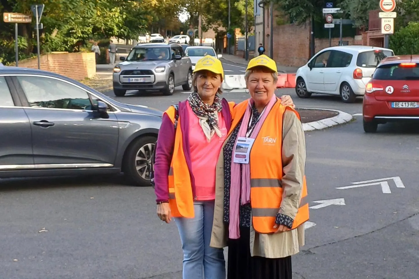Deux bénévoles en gilets orange mobilisées sur un parcours urbain